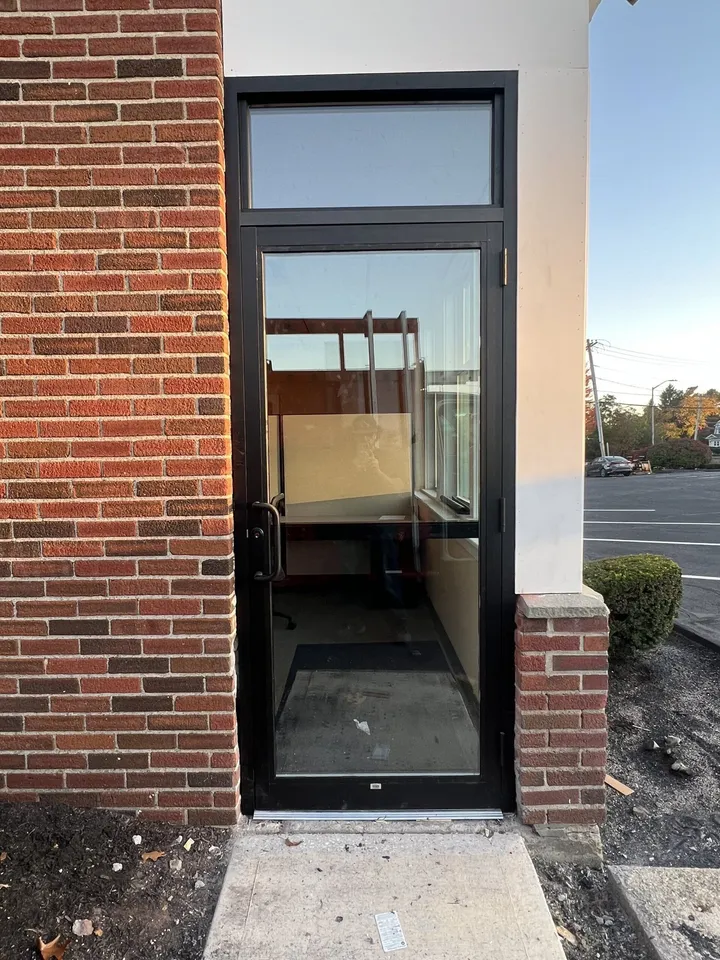 Commercial glass entry door installed in a brick storefront