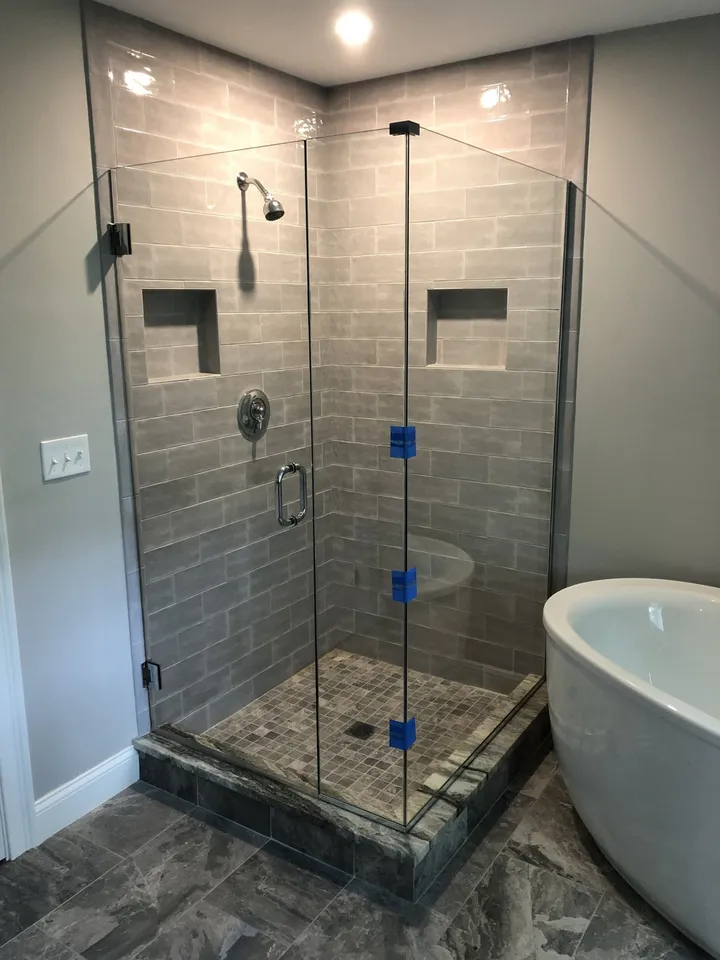 Frameless glass shower enclosure with a freestanding tub