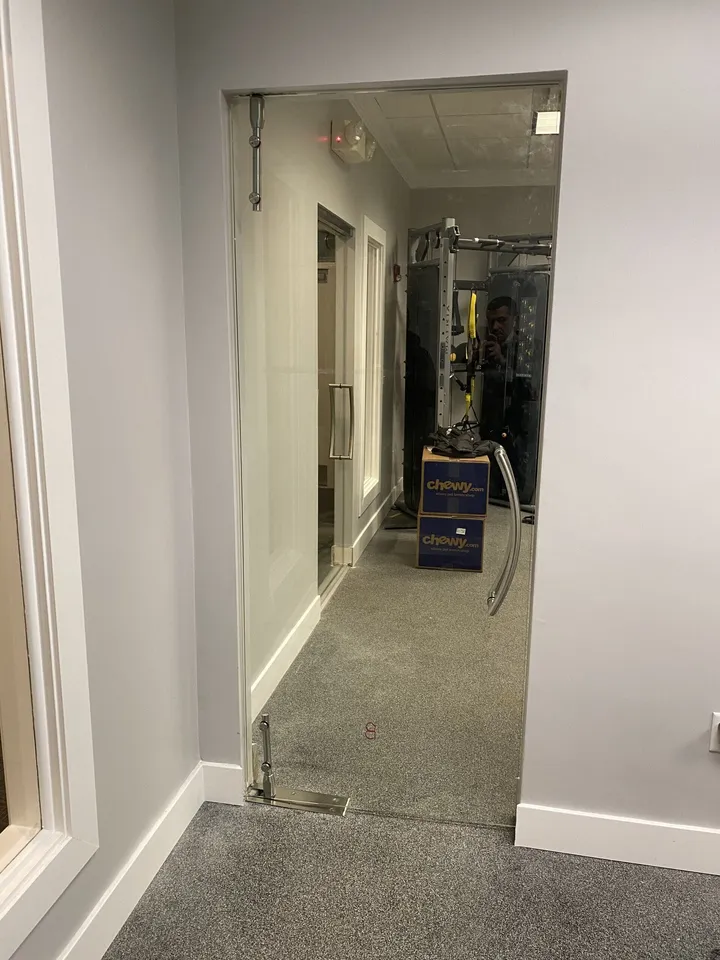 Frameless glass door opening into a home gym