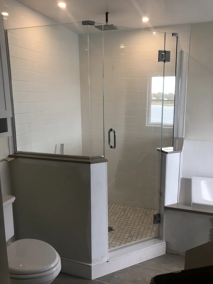 Glass shower enclosure with polished hardware