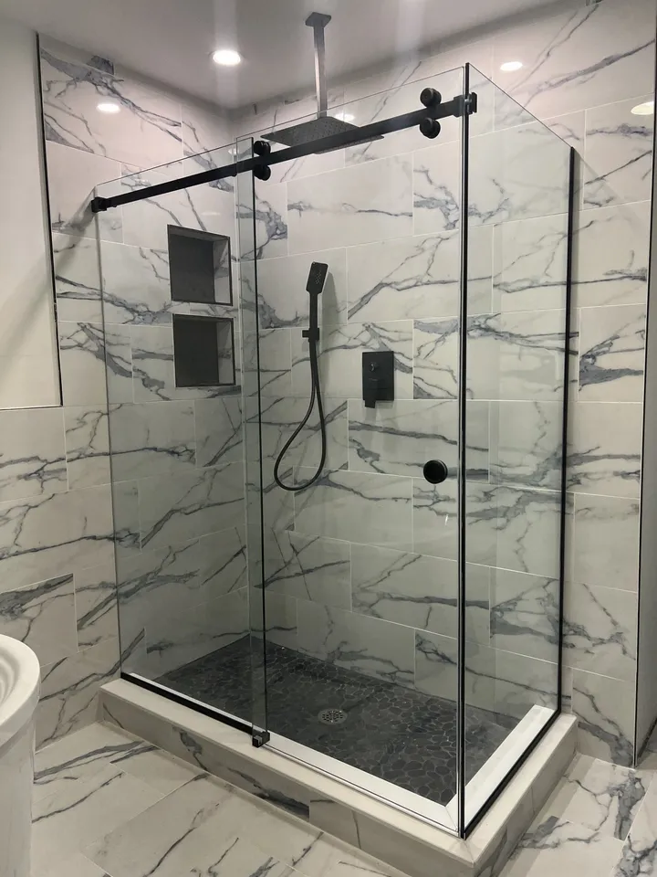 Frameless glass shower with marble walls and a niche