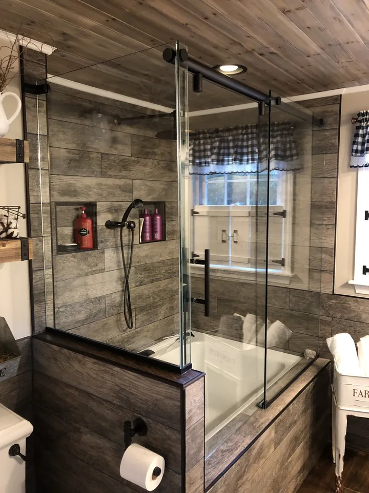 Glass shower enclosure beside a bathroom window