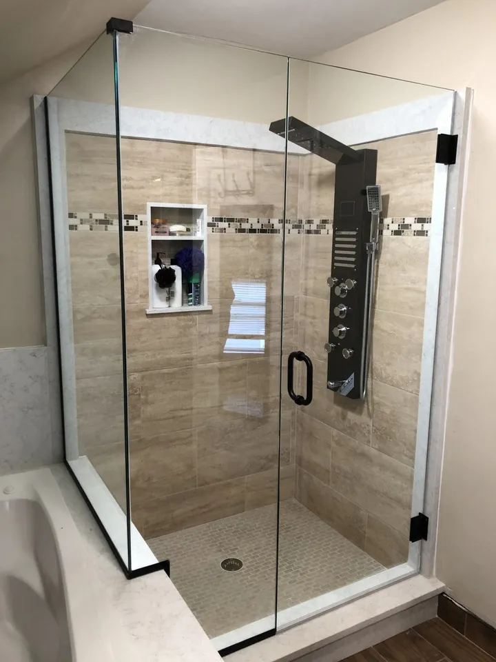 Glass shower enclosure with a wall shower panel