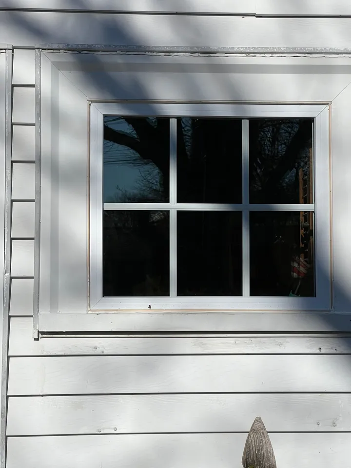 Replacement grid window installed in white siding