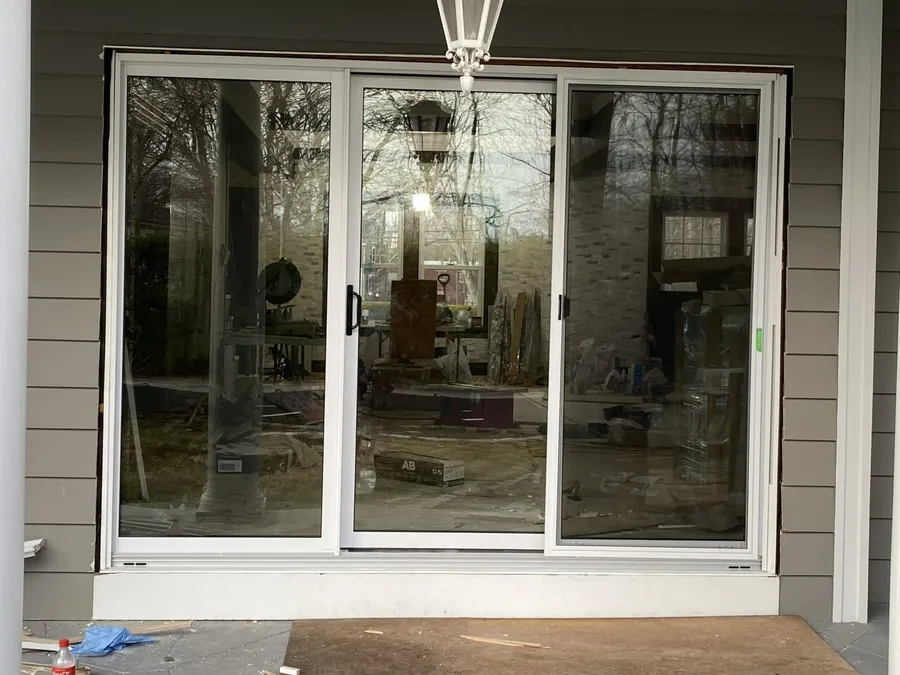 Three-panel sliding glass patio door installed on a covered porch