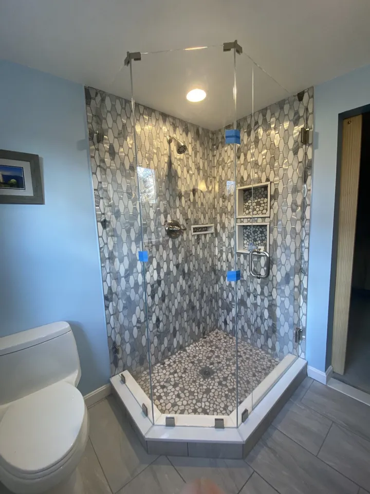 Glass shower enclosure with mosaic tile walls