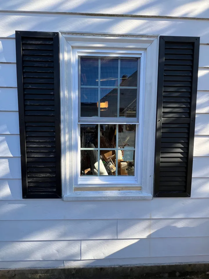 Replacement window fitted between black shutters
