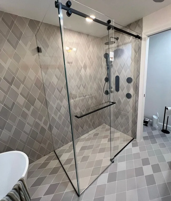Sliding glass shower enclosure with black hardware