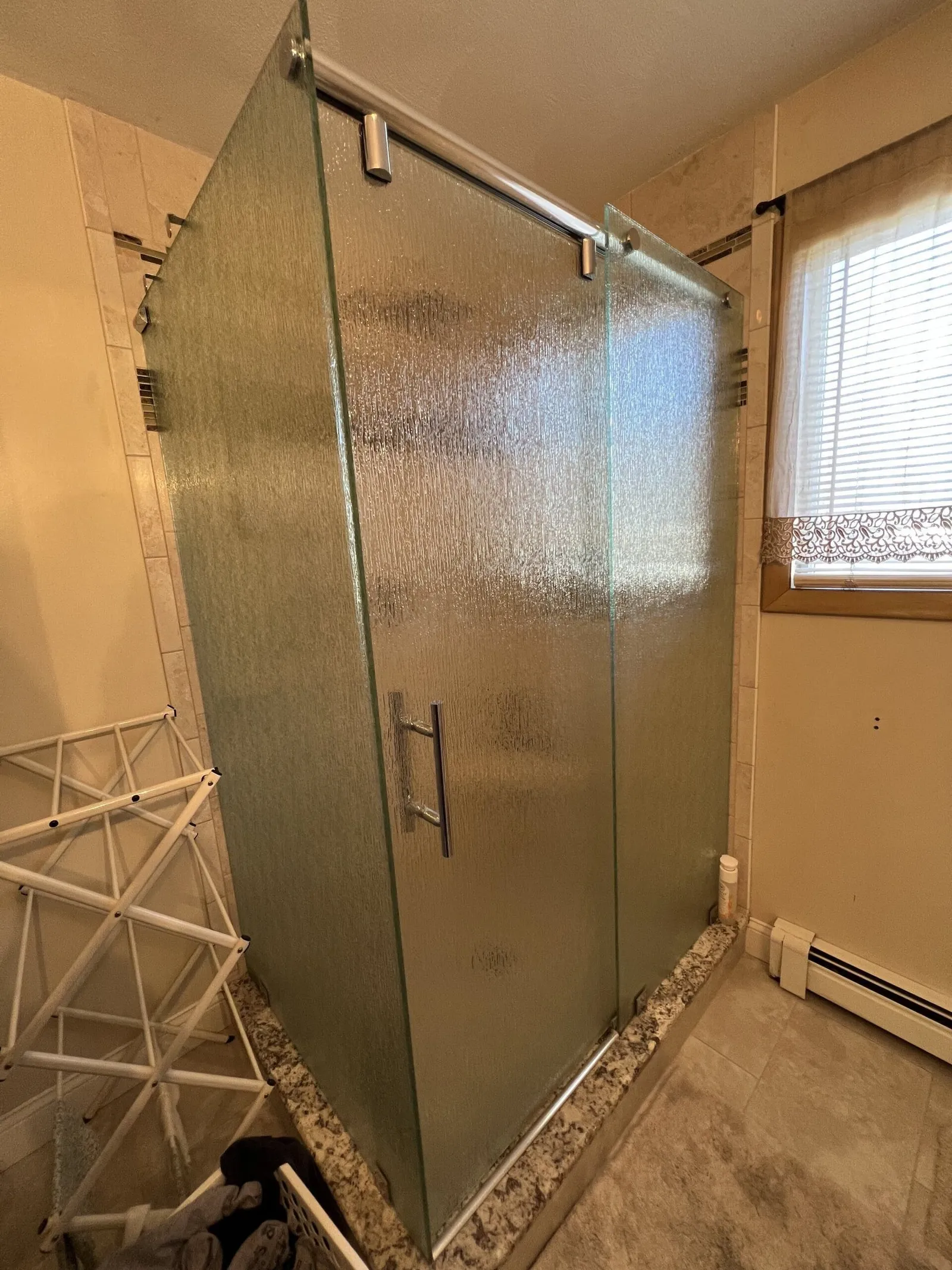 Textured privacy glass shower door in a remodeled bathroom