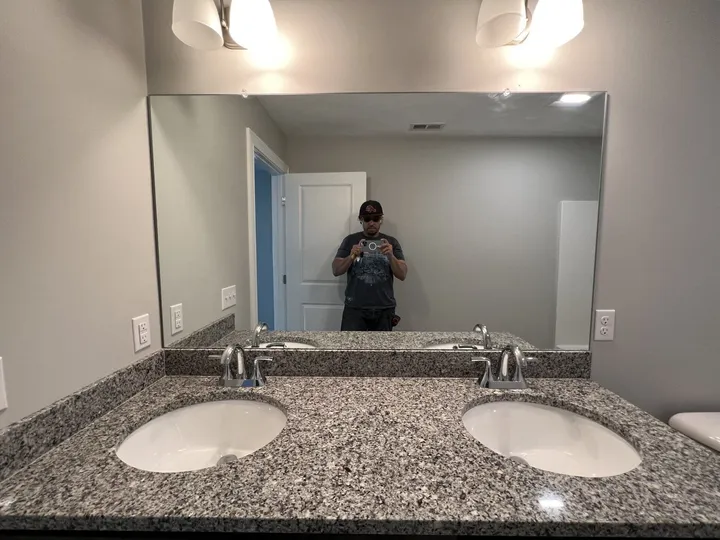 Vanity mirror installed above a granite double vanity